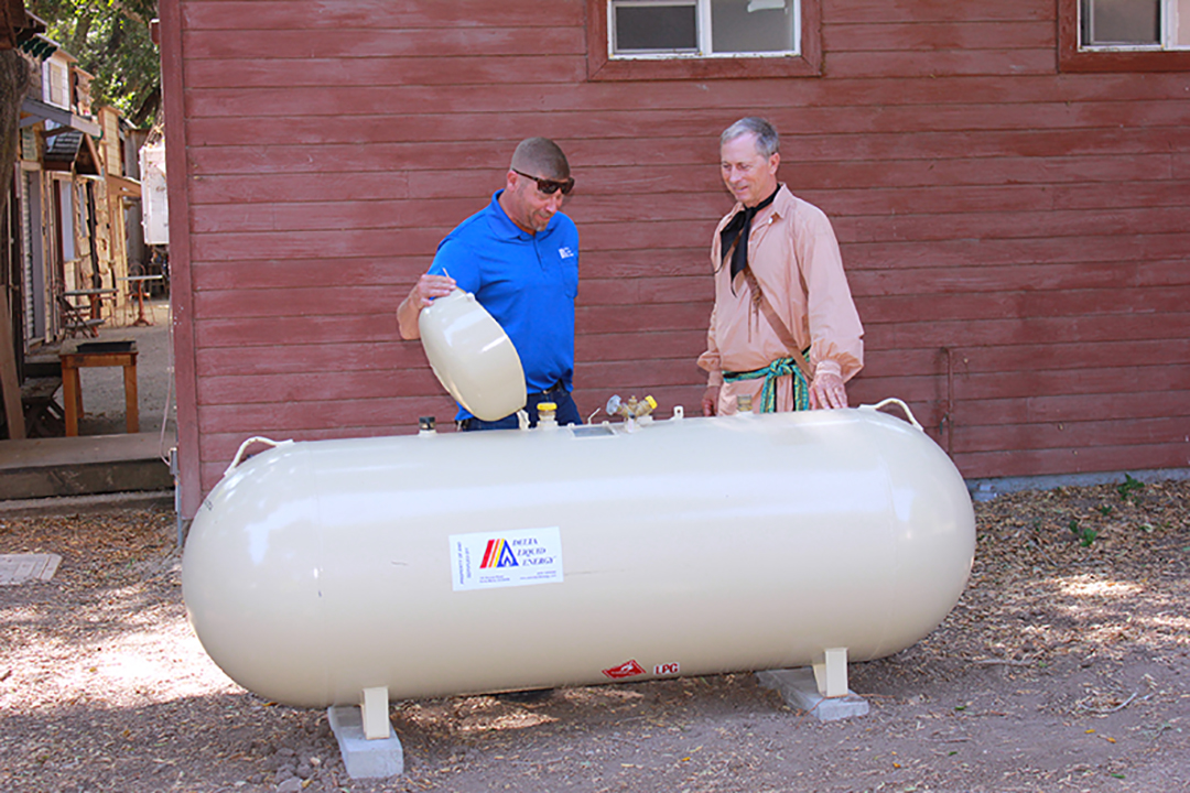two men checking propane tank safety features